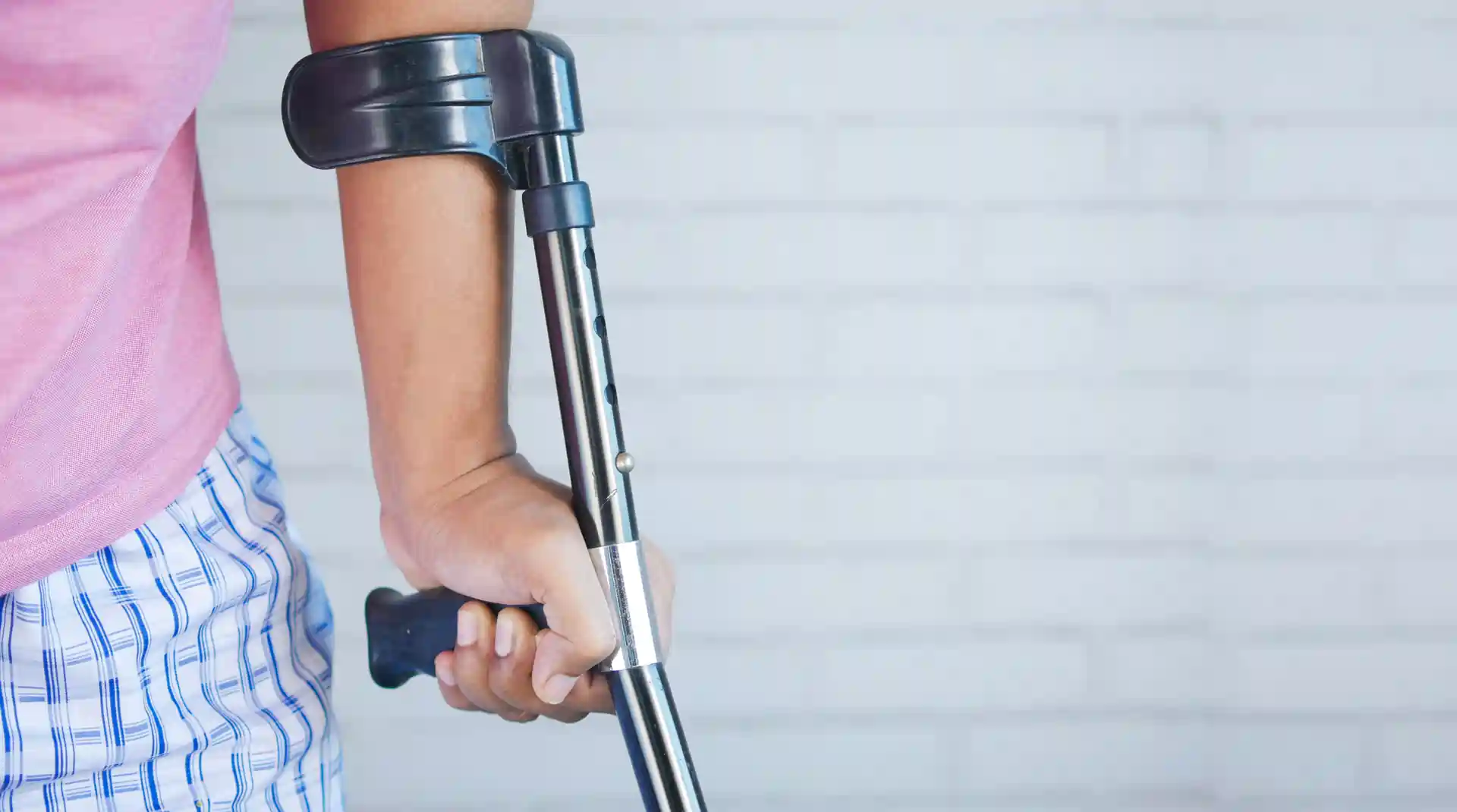 Close up of a person using crutches.